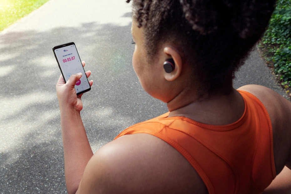 Des femmes utilisent l'application Wings for Life World Run avec des écouteurs de sport Philips